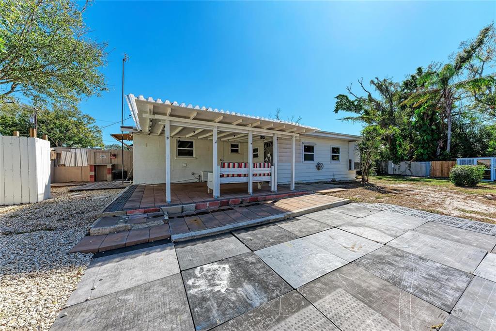 4010 South Lockwood Ridge Road Sarasota, FL 34231 - Photo 35 of 48 a view of a white house with a small yard and large tree