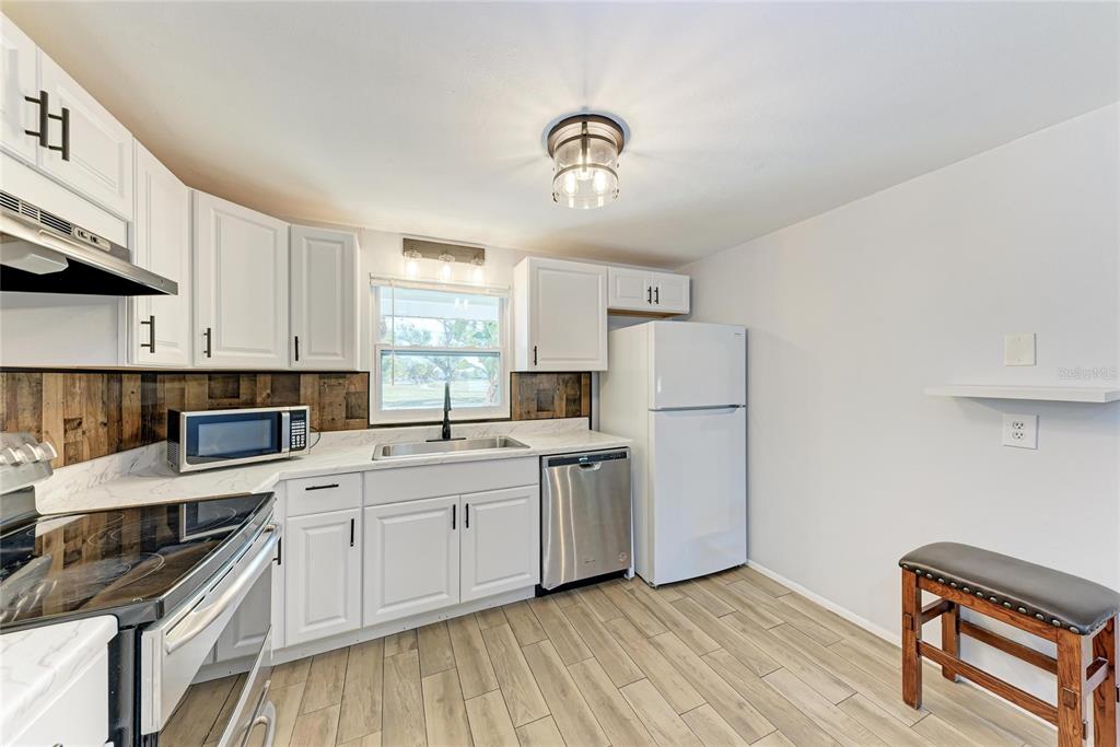 4010 South Lockwood Ridge Road Sarasota, FL 34231 - Photo 8 of 48 a kitchen with a sink cabinets stainless steel appliances and a window