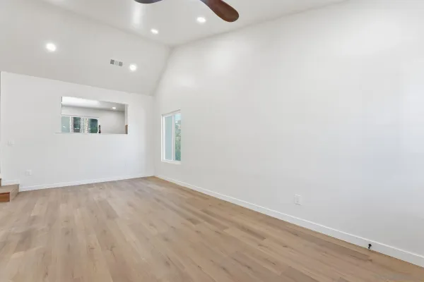 a view of an empty room with wooden floor