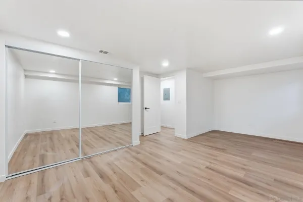 an empty room with a window and ceiling fan