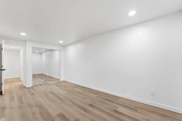 a view of empty room with wooden floor