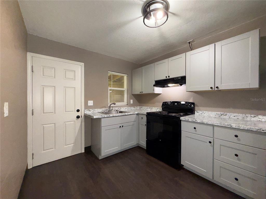 305 Marker Street Altamonte Springs, FL 32701 - Photo 4 of 15 a kitchen with granite countertop white cabinets and stainless steel appliances