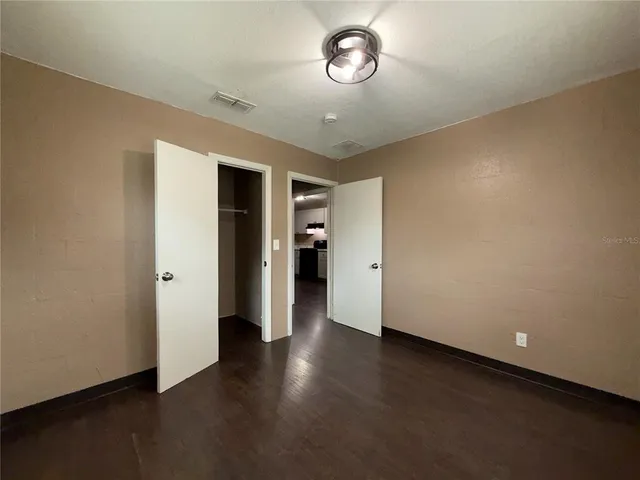an empty room with wooden floor and closet
