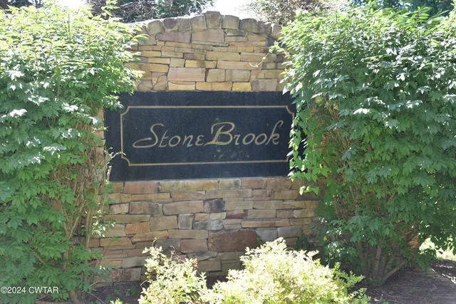 a sign that is sitting on a brick wall