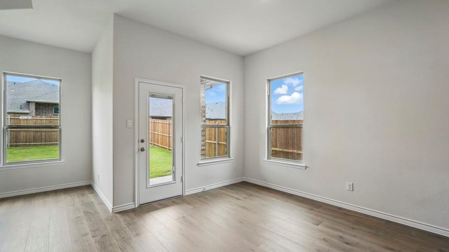 4187 Plateau Drive Forney, TX 75126 - Photo 12 of 36 an empty room with wooden floor and windows