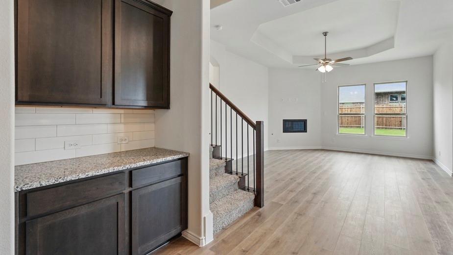 4187 Plateau Drive Forney, TX 75126 - Photo 16 of 36 a kitchen with granite countertop a stove a sink and a refrigerator with wooden floor