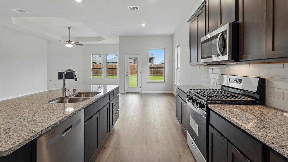 4187 Plateau Drive Forney, TX 75126 - Photo 2 of 36 a kitchen with stainless steel appliances granite countertop a sink stove and refrigerator