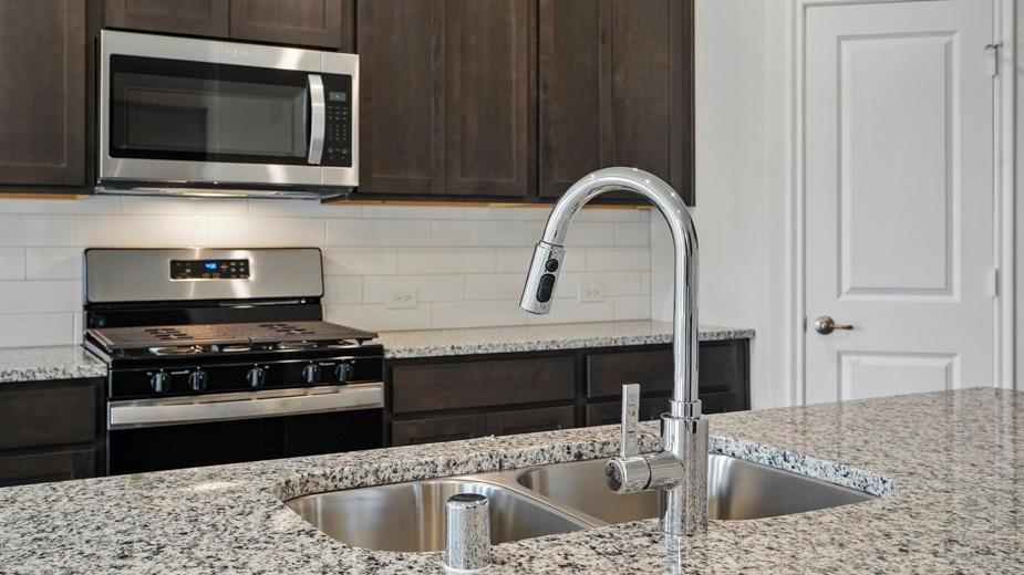 4187 Plateau Drive Forney, TX 75126 - Photo 3 of 36 a kitchen with stainless steel appliances granite countertop a stove microwave and sink