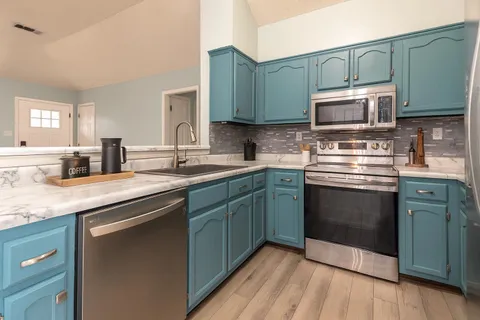 a kitchen with stainless steel appliances granite countertop a sink stove and microwave