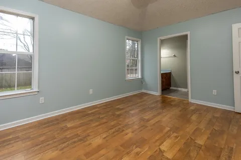 an empty room with windows and closet