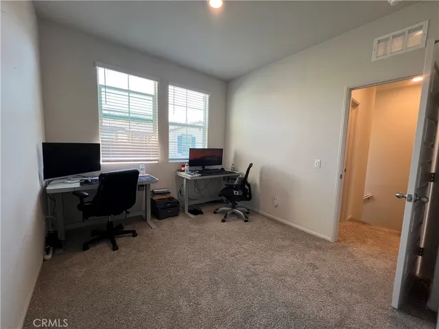 a view of a workspace with furniture and a window