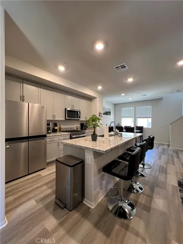 a kitchen with refrigerator cabinets and wooden floor