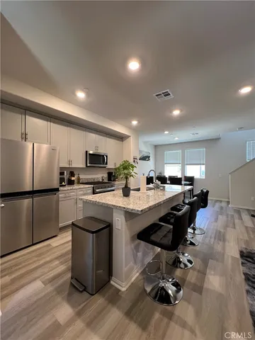 a kitchen with kitchen island a stove a sink a refrigerator and cabinets