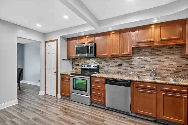 a kitchen with stainless steel appliances granite countertop a stove a sink dishwasher and a refrigerator