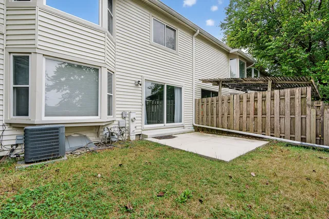 a view of backyard with wooden fence and a large tree