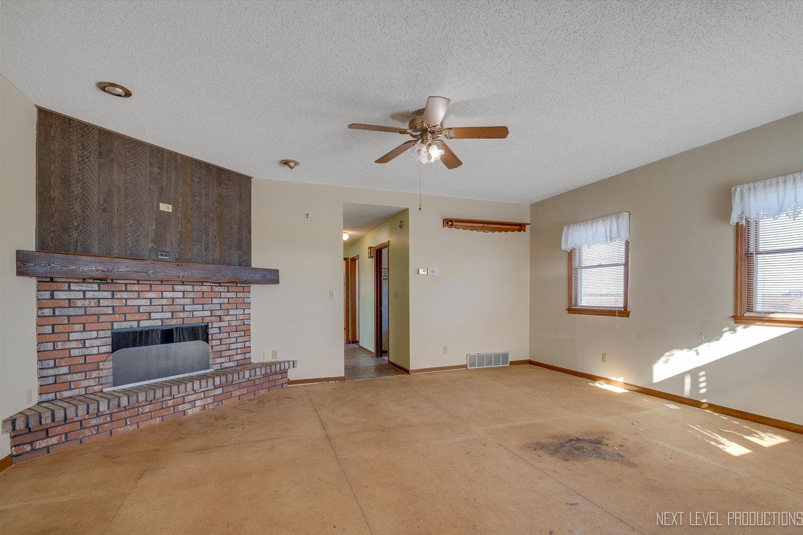 12029 Faxon Road Plano, IL 60545 - Photo 5 of 26 a view of empty room with fireplace and fan