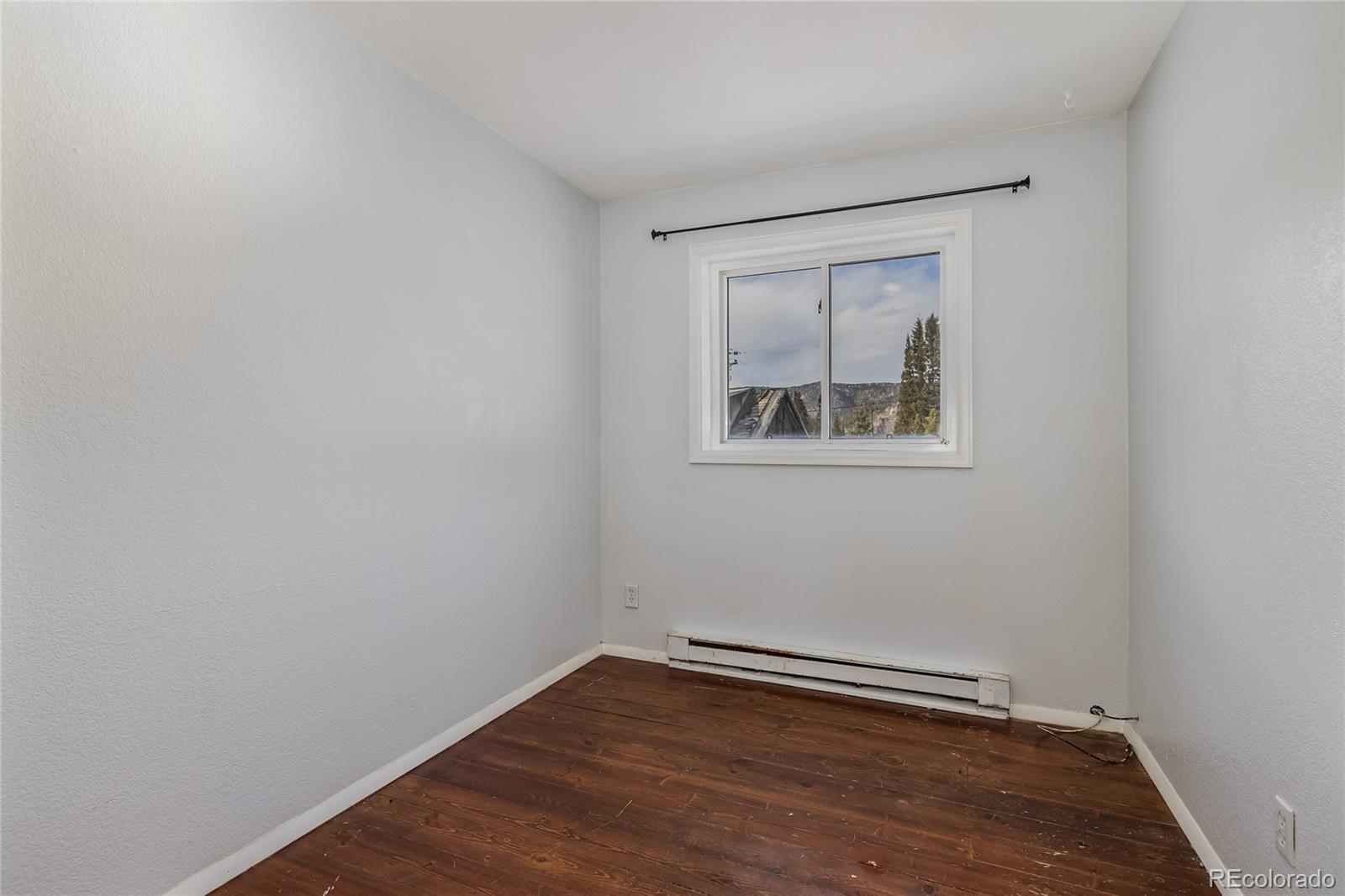 5355 Montezuma Road Montezuma, CO 80435 - Photo 26 of 50 a view of an empty room with wooden floor and a window