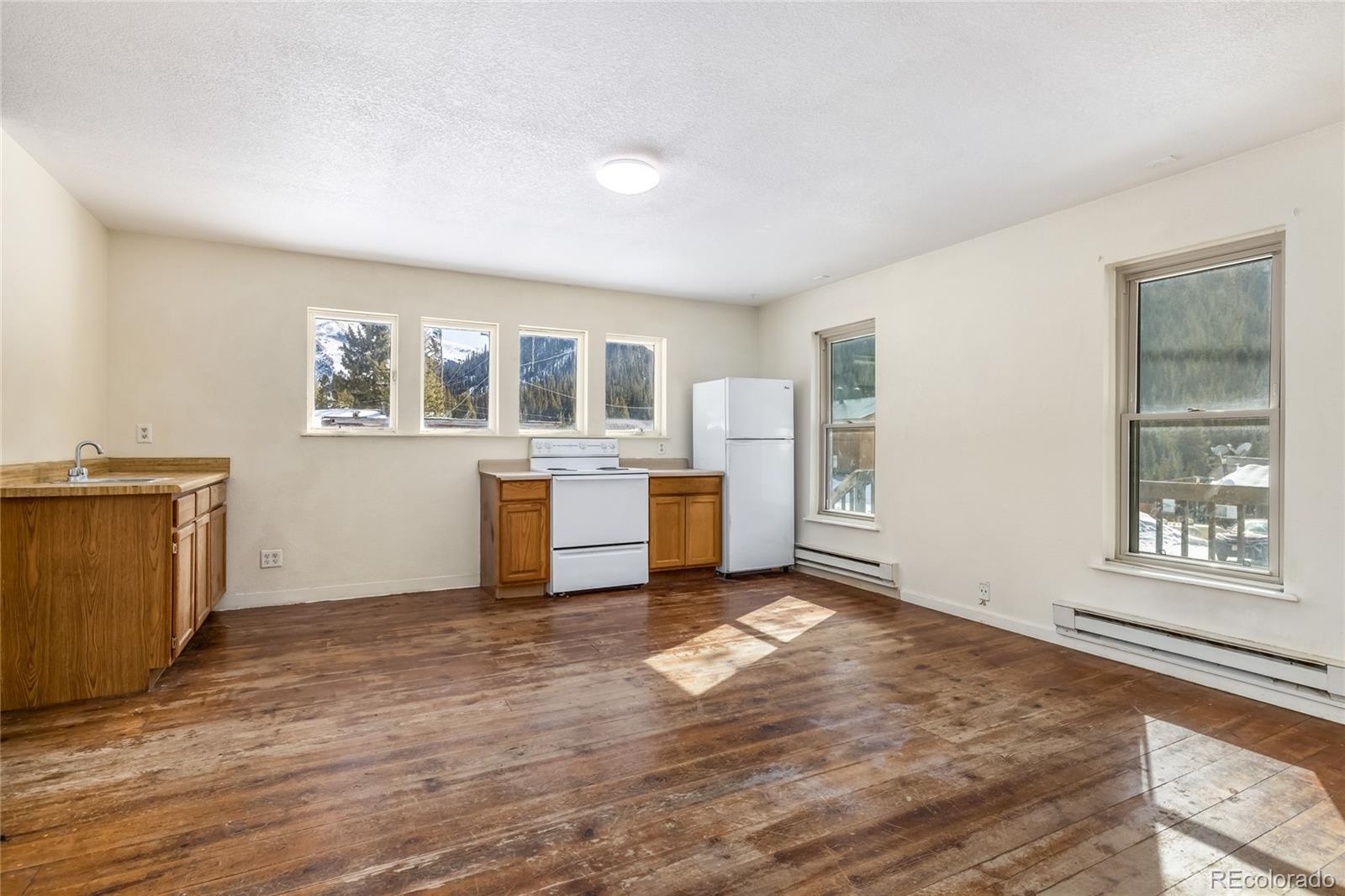 5355 Montezuma Road Montezuma, CO 80435 - Photo 34 of 50 a view of an empty room with a window and wooden floor