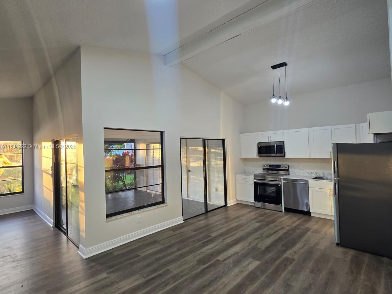 a kitchen with stainless steel appliances granite countertop a refrigerator stove top oven and sink