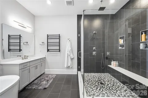 a bathroom with a double vanity sink a toilet and shower