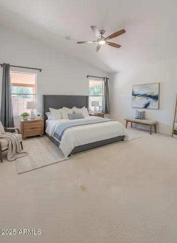a spacious bedroom with a bed a couch and a chandelier