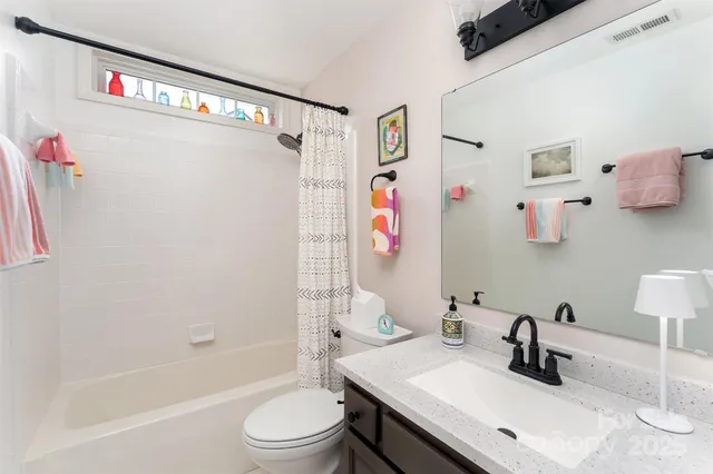 a bathroom with a sink vanity mirror and toilet