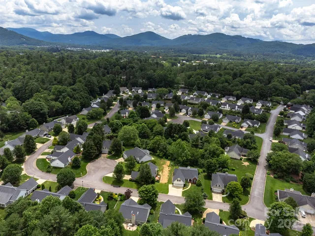 an aerial view of a city with lots of residential buildings and mountain view in back