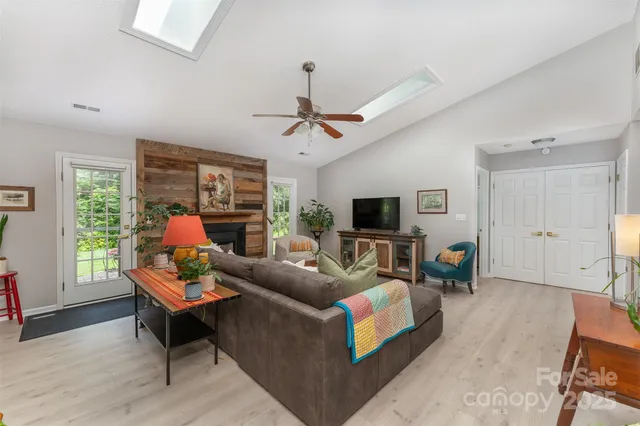 a living room with furniture a flat screen tv and a large window