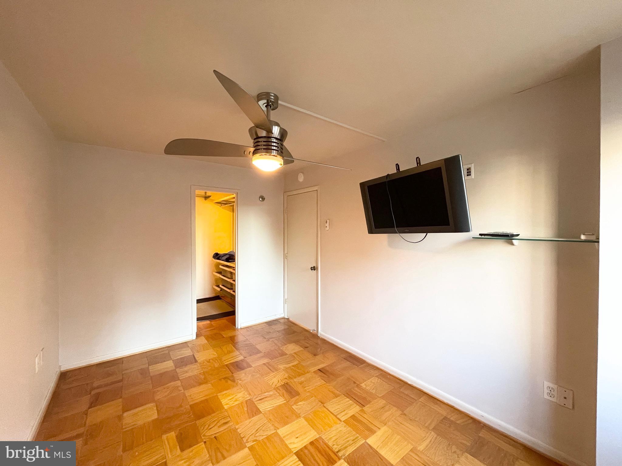 2939 Van Ness Street Northwest, Unit 737 Washington, DC 20008 - Photo 11 of 18 a view of a livingroom with a flat screen tv and ceiling fan
