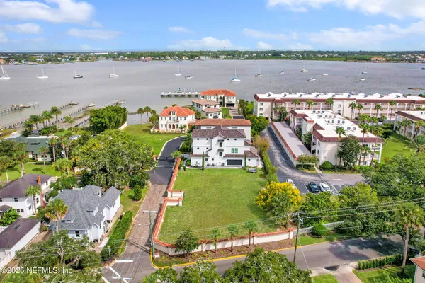 an aerial view of a city with lots of residential buildings ocean and mountain view in back
