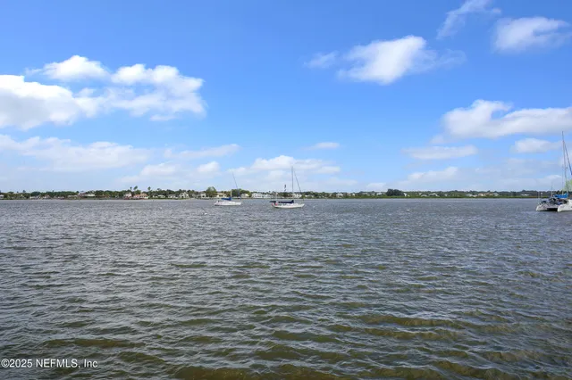 a view of a lake with boats and trees in the background