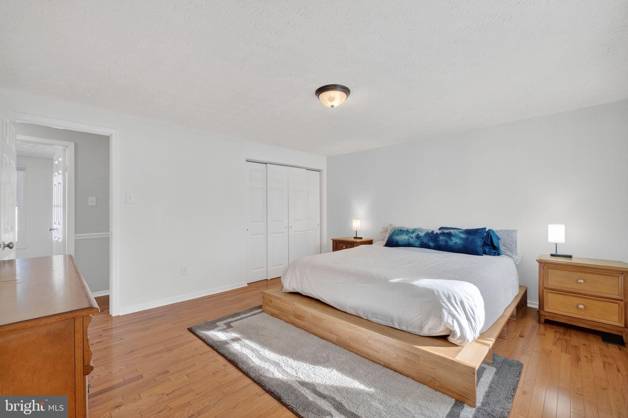 12608 Carland Place Laurel, MD 20708 - Photo 12 of 38 a bedroom with a bed and wooden floor