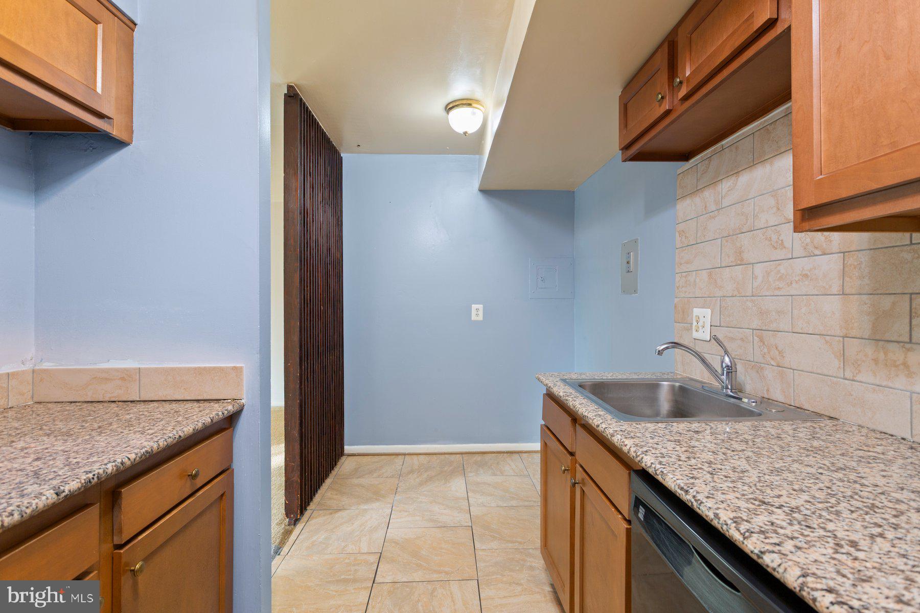 2305 Greenery Lane, Unit T43 Silver Spring, MD 20906 - Photo 19 of 30 a kitchen with granite countertop a sink and a refrigerator