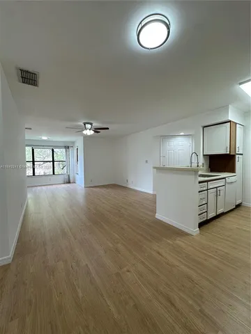 a view of a livingroom with furniture wooden floor and a ceiling fan