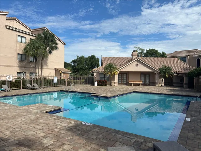 a front view of a house with swimming pool having outdoor seating