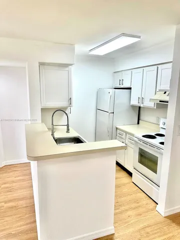 a kitchen with a sink a stove and refrigerator