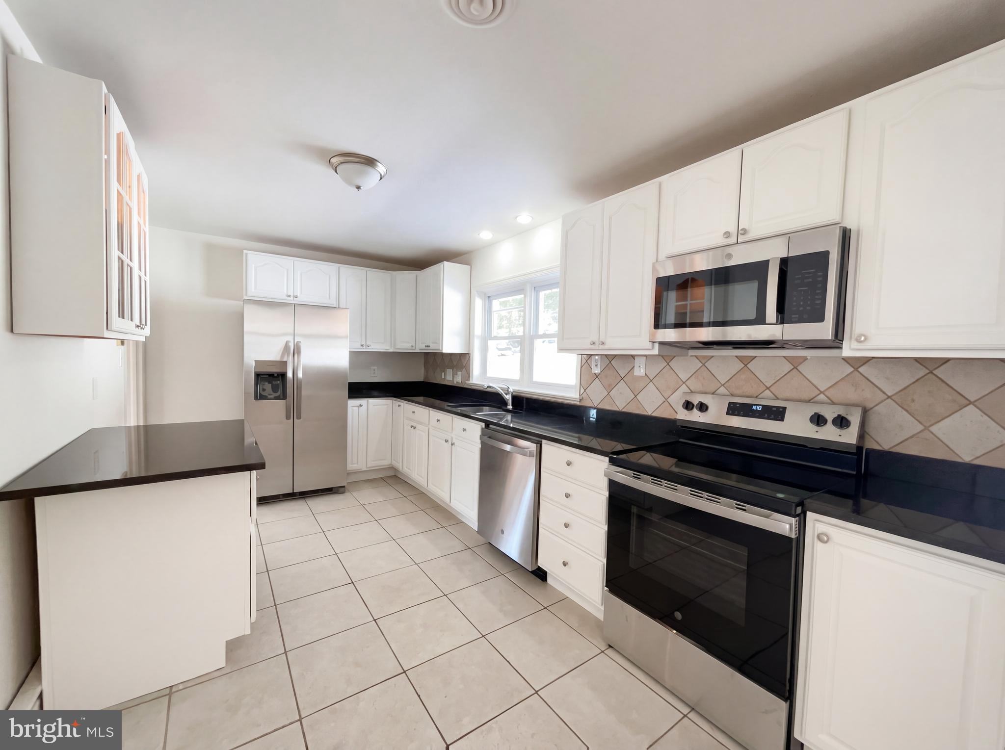 6048 Old Telegraph Road Alexandria, VA 22310 - Photo 4 of 43 a kitchen with stainless steel appliances granite countertop a stove microwave and sink