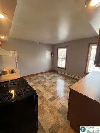 a kitchen with granite countertop white cabinets and black appliances