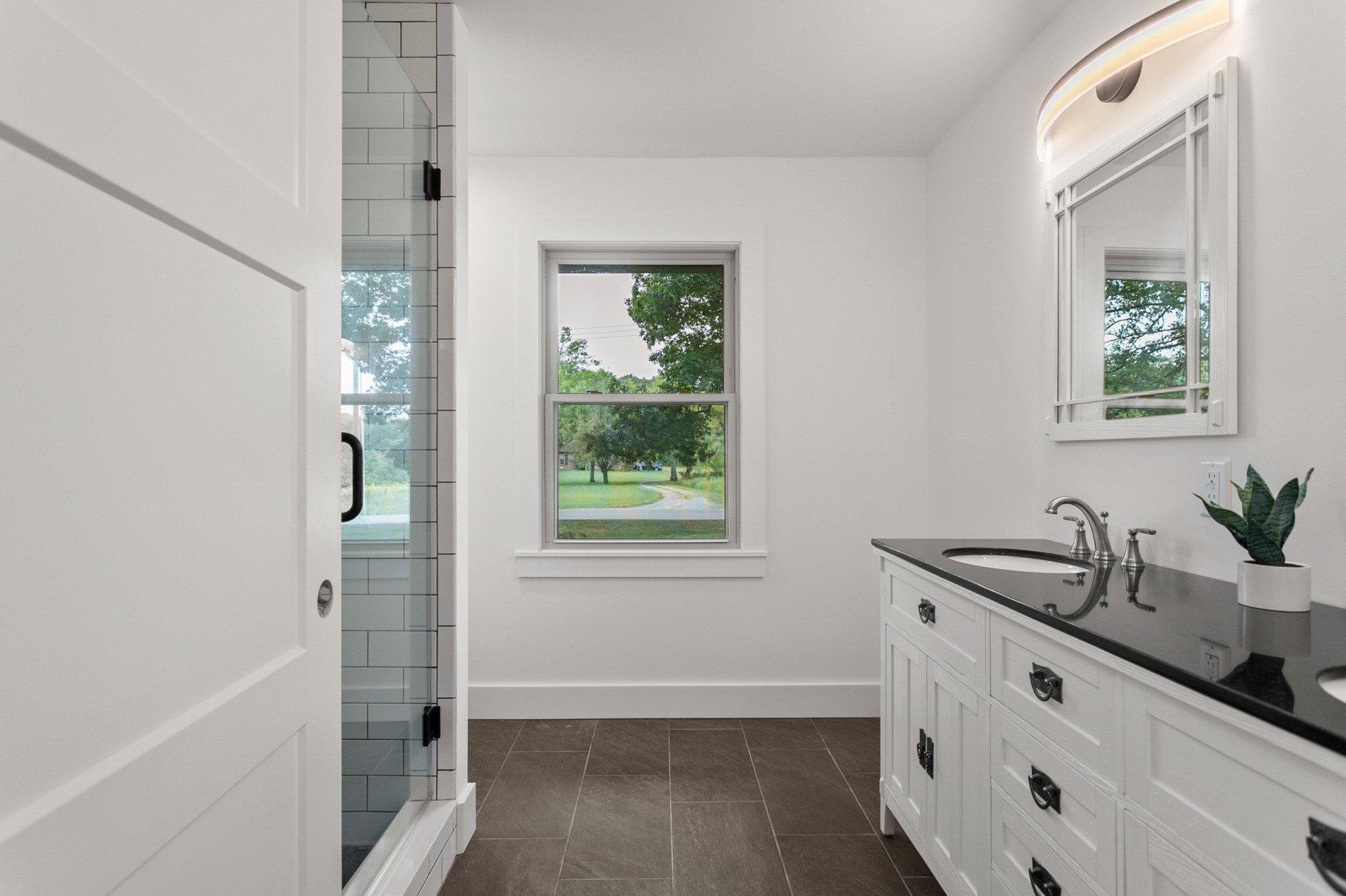 2338 North Road Murfreesboro, TN 37128 - Photo 21 of 48 a bathroom with a granite countertop sink a mirror a window and a bathtub