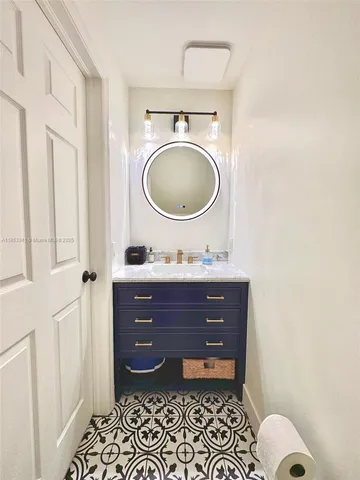 a bathroom with a sink vanity mirror and toilet