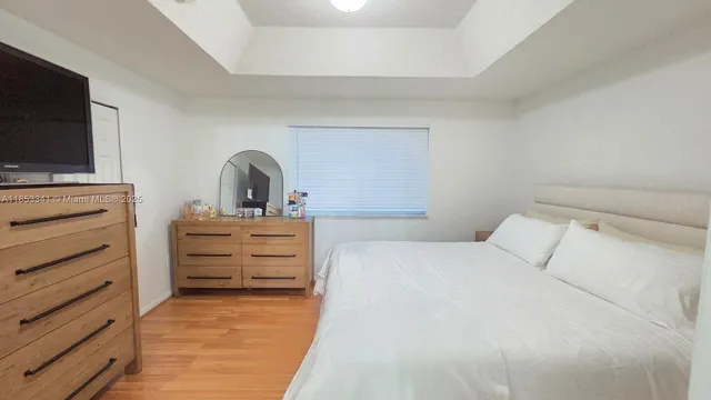 a bedroom with a bed and a wooden floor