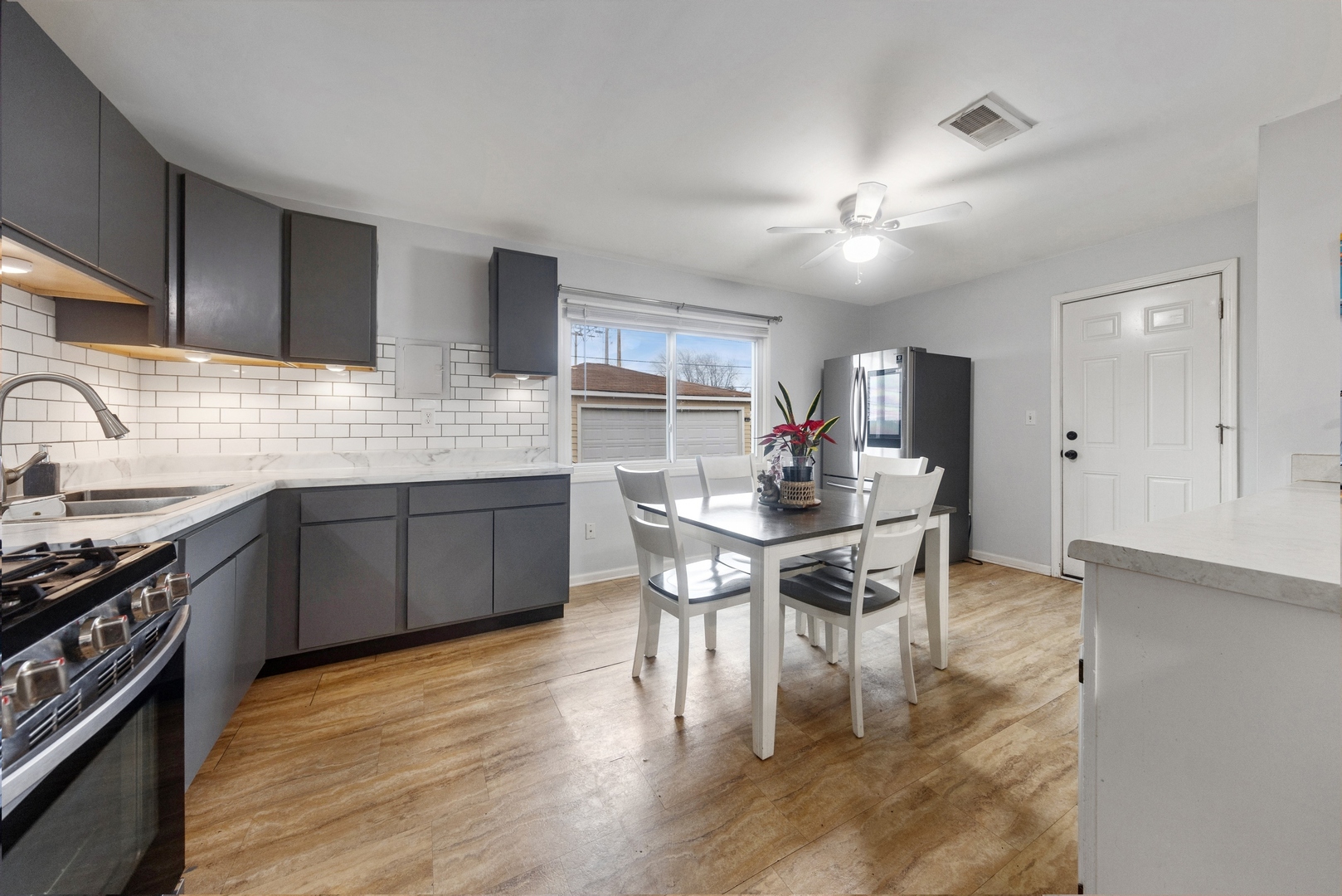 335 Macon Avenue Romeoville, IL 60446 - Photo 6 of 19 a kitchen with a dining table chairs stainless steel appliances and cabinets