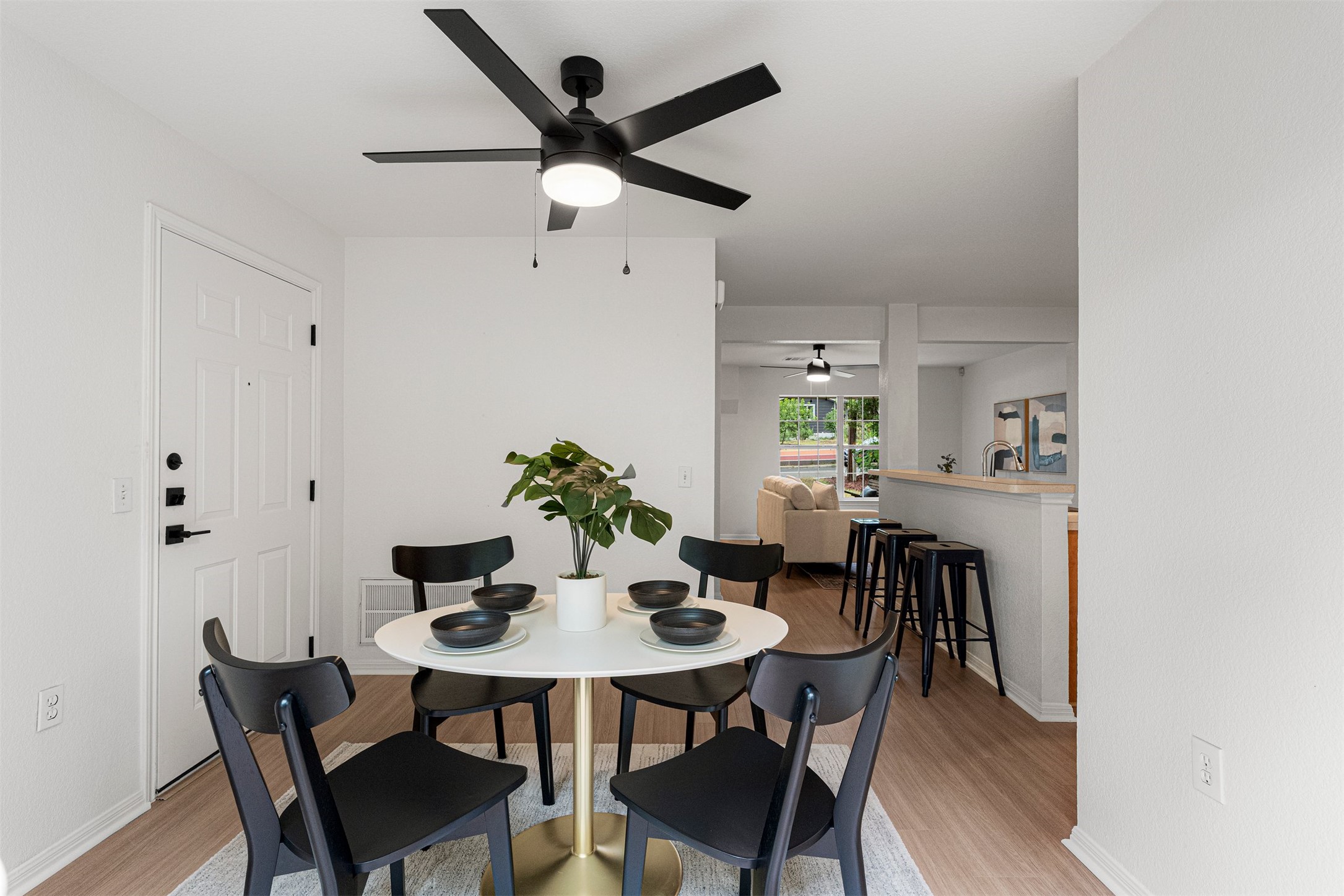 3003 Glen Rae Street Austin, TX 78702 - Photo 16 of 38 A modern ceiling fan hangs above, adding comfort and a touch of contemporary design to this dedicated dining space, bordered by the same vinyl plank flooring and neutral walls