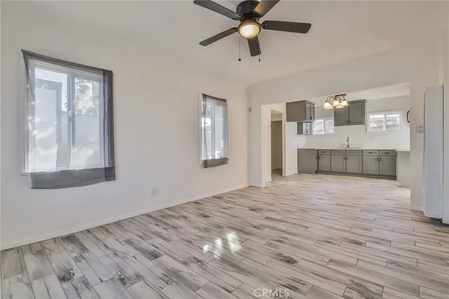 a view of empty room with wooden floor and window
