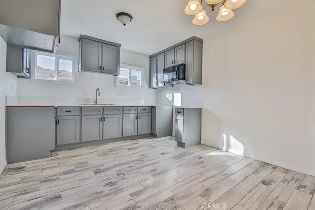 an empty room with wooden floor and hallway