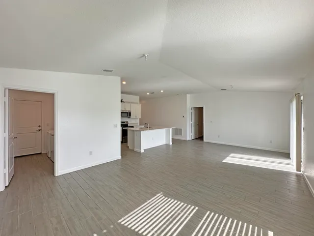 a view of a big room with wooden floor and windows