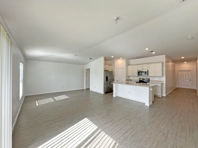 a view of kitchen with kitchen island white cabinets and refrigerator