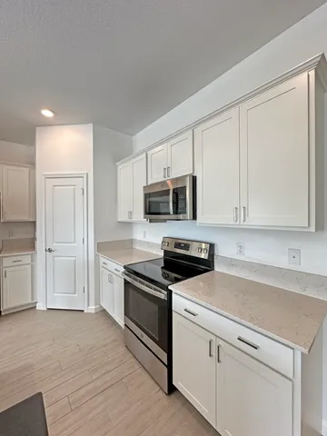 a kitchen with stainless steel appliances granite countertop a stove a sink and a microwave