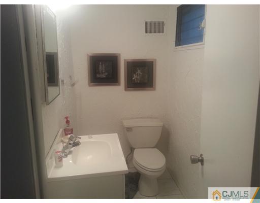 46 Harmon Road Edison, NJ 08837 - Photo 14 of 17 a bathroom with a toilet a sink and mirror