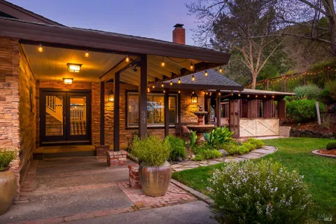a view of a house with backyard and sitting area